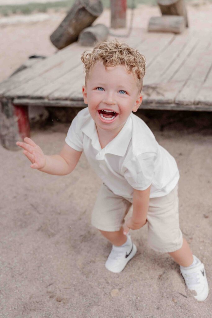 bedürfnisorientierte Kitafotografie – Kind springt vom Klettergerüst im Kindergarten