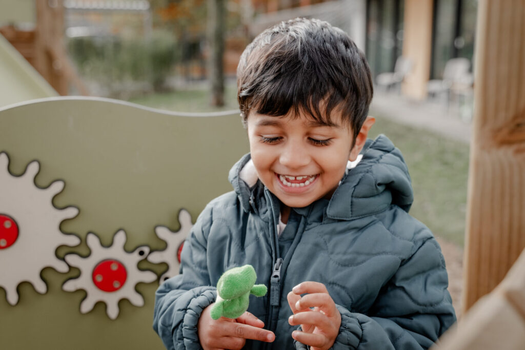 über mich - Kind spielt mit Handpuppe – Kitafotografie im freien Spiel